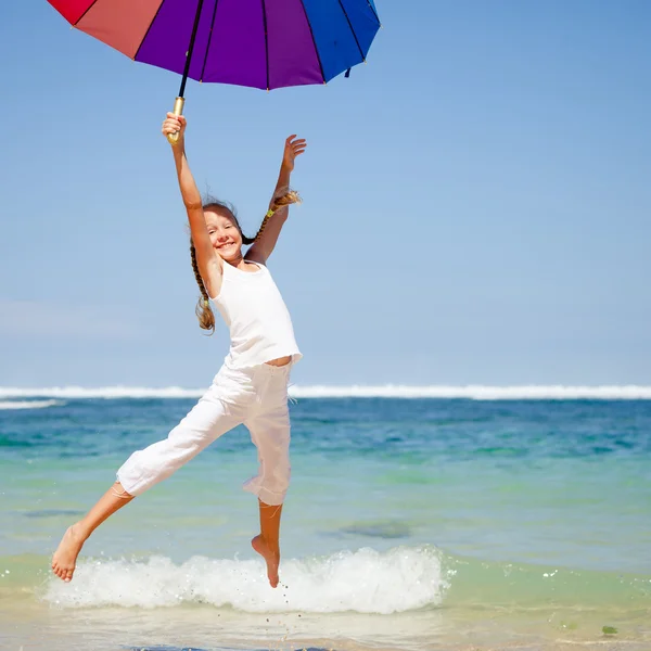 Teen girl  jumping on the beach at blue sea shore in summer vaca — Stock Photo, Image