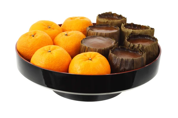 Мандаринские апельсины и рисовые пирожные — стоковое фото