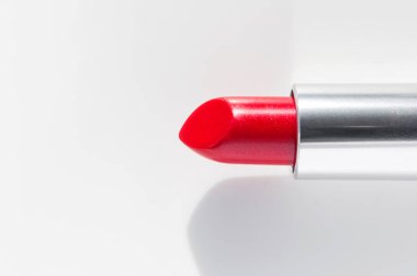 Beyaz arka planda kırmızı ruj. Güzellik ve kozmetik geçmişi. Dekoratif kozmetik ürünler, makyaj, kadın ruju, güneş yanığı, güzellik markası, ürün tasarımı. Düz görünüm kopyalama alanı.