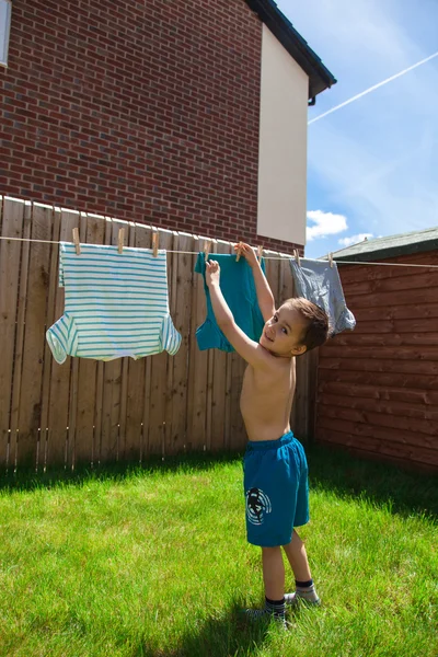 Criança pendurando suas camisas — Fotografia de Stock