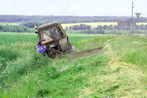 草刈りする機械芝刈り機が付いているトラクター — ストック写真