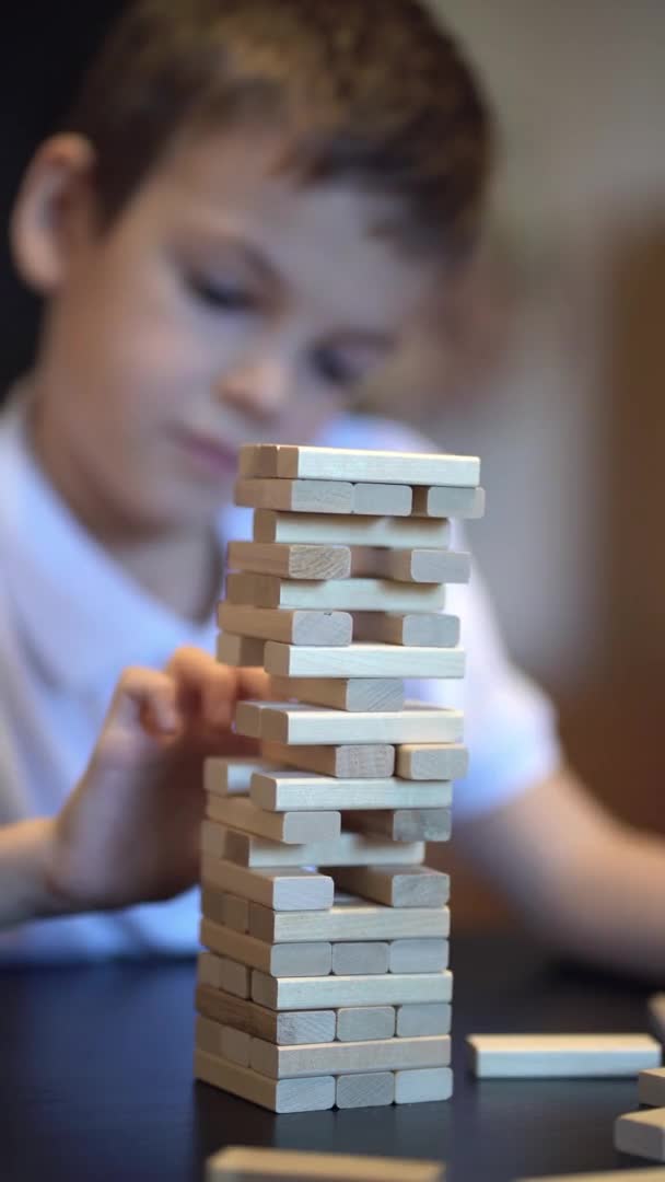 Jongen spelen in bordspel met houten toren thuis — Stockvideo