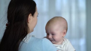 Genç anne kucağında yeni doğmuş bir çocuğu tutuyor.