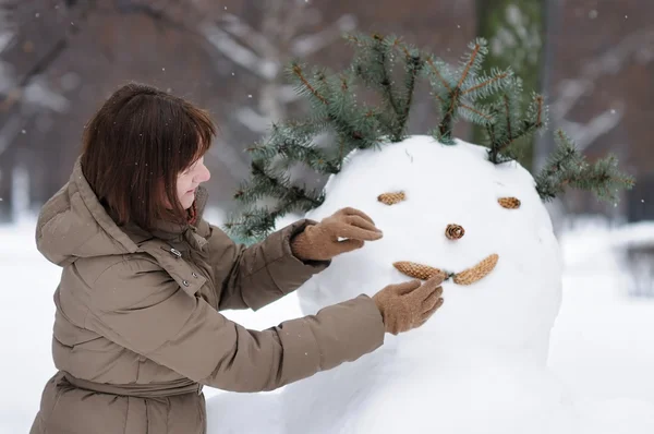 Heureuse femme d'âge moyen et bonhomme de neige — Photo