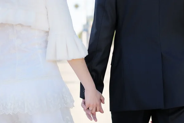 Bride and groom holding hands — Stock Photo, Image