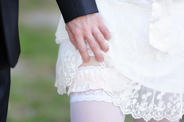 Uomo che rimuove la giarrettiera da una donna appena sposata — Foto Stock