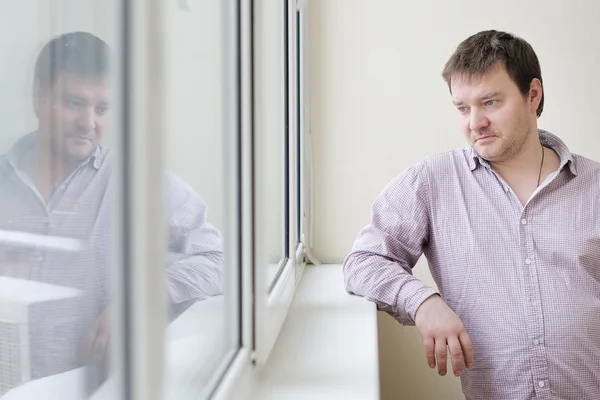 Man looking at snow into the window — Stock Photo, Image