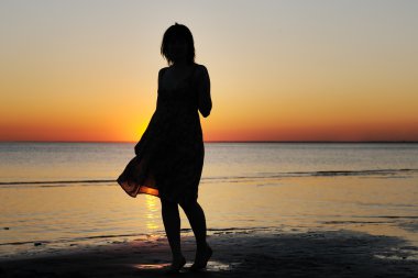 vrouw als silhouet door de zee