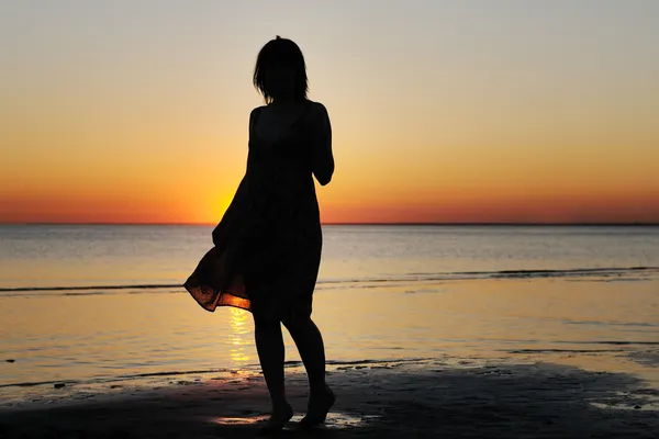 Vrouw als silhouet door de zee — Stok fotoğraf