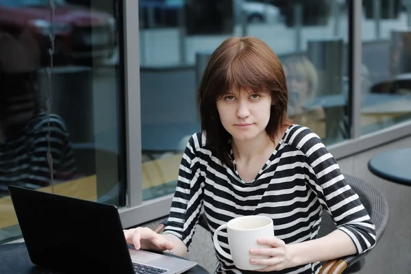 Menina usando laptop em um café ao ar livre — Fotografia de Stock