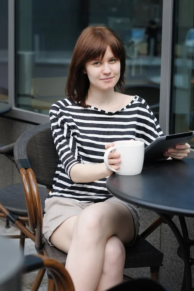 Девушка пьет кофе в кафе на открытом воздухе — стоковое фото