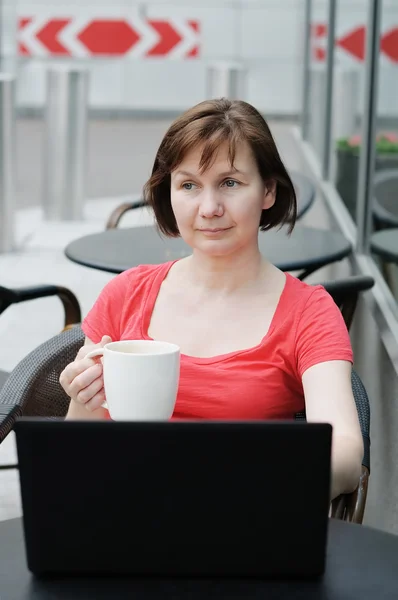 Kvinna dricker kaffe på en uteservering — Stockfoto