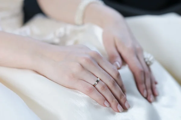Mão da noiva que coloca em um vestido branco — Fotografia de Stock