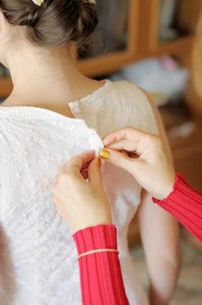 Ajudando a noiva a colocar seu vestido de noiva — Fotografia de Stock