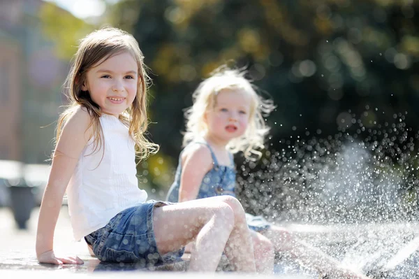 Сестры веселятся в городском фонтане — стоковое фото