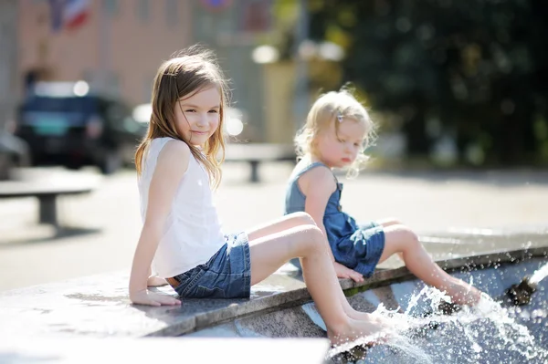 Meisjes met plezier in een fontein — Stockfoto