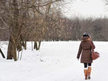 Kış parkında genç bir kadın 