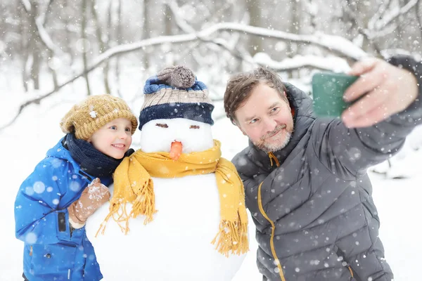 Kleine Jongen Zijn Vader Nemen Selfie Achtergrond Van Sneeuwpop Snowy — Stockfoto