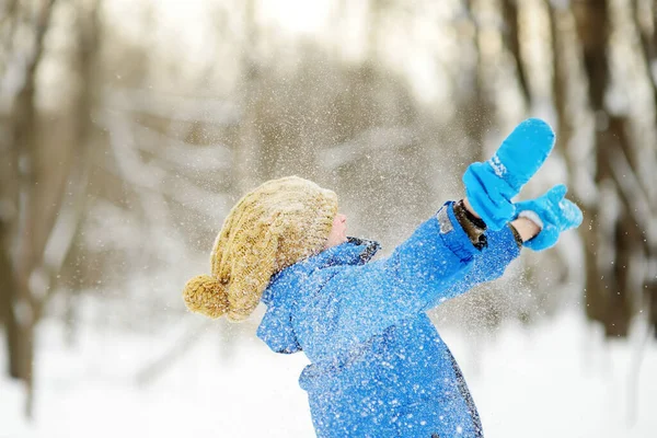 冬の公園で新鮮な雪で遊んでいる小さな子供 かわいい面白い男の子が雪を投げます 赤ちゃん暖かい服 スカーフを着て 子供連れの家族のための屋外冬の活動 — ストック写真