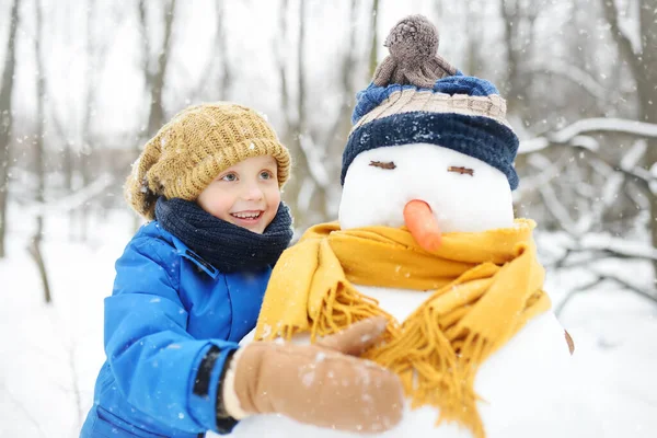 Niño Construyendo Muñeco Nieve Parque Nevado Niño Abrazando Muñeco Nieve —  Fotos de Stock