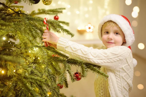 小男孩戴着圣诞礼帽 准备庆祝圣诞节 可爱的孩子用甜糖果装饰圣诞树 在新年的夜晚 婴儿对魔法和礼物的希望 寒假前后的传统 — 图库照片