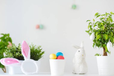 Renkli yumurtalar, şirin küçük tavşanlar ve Paskalya günü masanın üstünde tavşan kulakları. Baharda Paskalyayı kutluyoruz. Yumurta boyamak. Tatil için ev dekorasyonu.