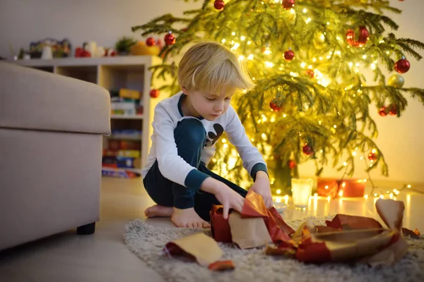 可爱的小男孩打开了圣诞礼物 圣诞节清晨快乐孩子的画像 舒适的客厅 装饰着冷杉树 — 图库照片