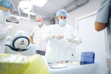 Diş ameliyatı sırasında cerrah ve hemşire. Anestezi yapılmış hasta ameliyathanede. Diş implantı ya da diş çıkarma kliniğine yerleştirilmiş. Ortodonti ameliyatı sırasında genel anestezi..