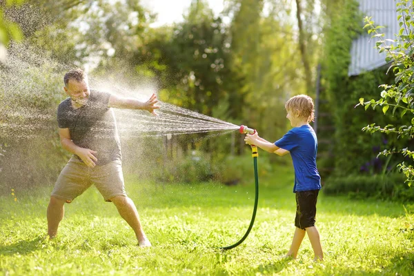 Divertido Niño Pequeño Con Padre Jugando Con Manguera Jardín Patio — Foto de Stock