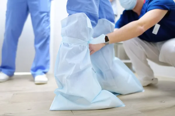 Asystent Pomaga Chirurgowi Założyć Ochraniacze Buty Medyczne Doktor Przygotowuje Się — Zdjęcie stockowe