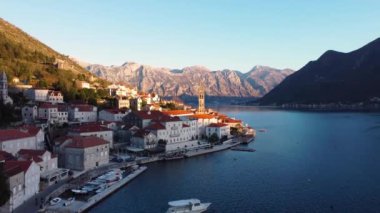 Antik Perast, Montenegro kentinin panoramik günbatımı drone görüntüsü. Arka planda kırmızı çatıları ve görkemli dağları olan eski bir ortaçağ kasabası. Adriyatik Denizi kıyısında resim gibi Kotor Körfezi..