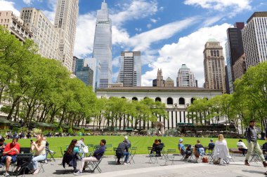 New York, ABD - 11 Mayıs 2021: İnsanlar Manhattan, New York 'taki Bryant Park' ta güneşli bir bahar gününün keyfini çıkarıyorlar.