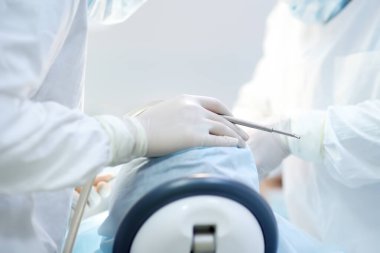 Diş ameliyatı sırasında cerrah ve hemşire. Anestezi yapılmış hasta ameliyathanede. Diş implantı ya da diş çıkarma kliniğine yerleştirilmiş. Ortodonti ameliyatı sırasında genel anestezi..