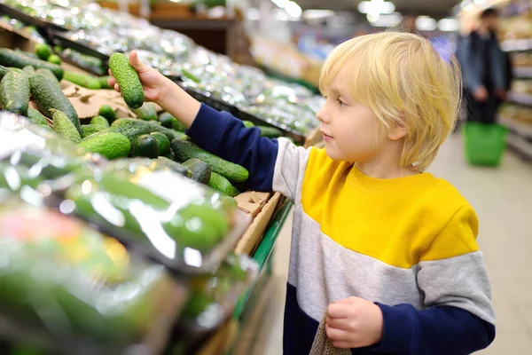 Menino Bonito Uma Loja Alimentos Supermercado Escolhendo Pepinos Orgânicos Frescos — Fotografia de Stock