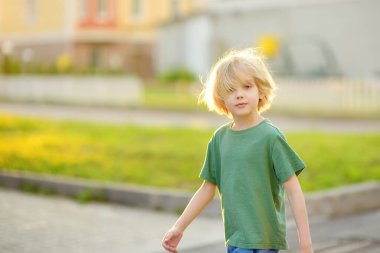 Neşeli küçük çocuk güneşli yaz tatilinin tadını çıkarıyor. Küçük bir kasabanın sokaklarında oynayan aktif bir çocuk. Özgürlük, dinlenme, tatil ve çocukluk kavramı. Mutlu çocuk dışarıda.