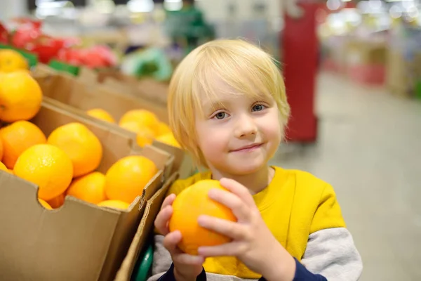 Leuk Jongetje Een Levensmiddelenwinkel Supermarkt Die Verse Biologische Sinaasappels Kiest — Stockfoto