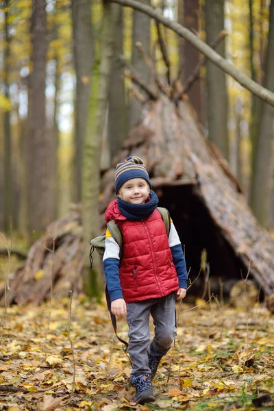 秋の森の中をハイキング中の少年スカウト 子供の後ろにはティーピー小屋がある 子供のための冒険 スカウティング ハイキング観光の概念 — ストック写真