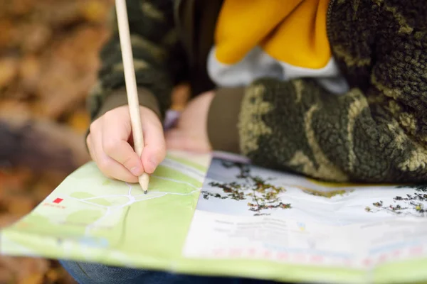 Lilla Pojkscouten Orienterar Sig Skogen Barnet Tittar Kartan Bakgrunden Kåtboden — Stockfoto