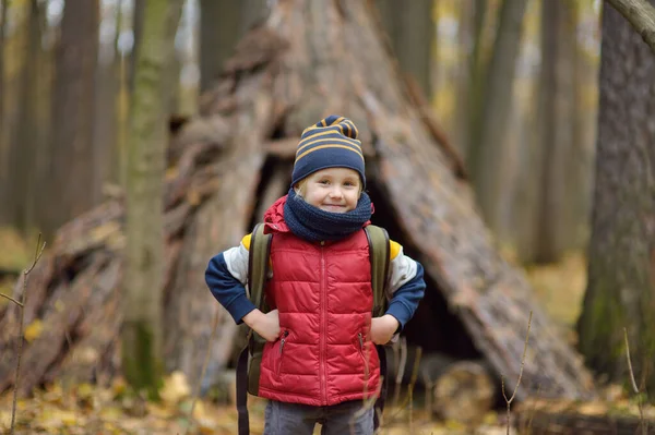 秋の森の中をハイキング中の少年スカウト 子供の後ろにはティーピー小屋がある 子供のための冒険 スカウティング ハイキング観光の概念 — ストック写真