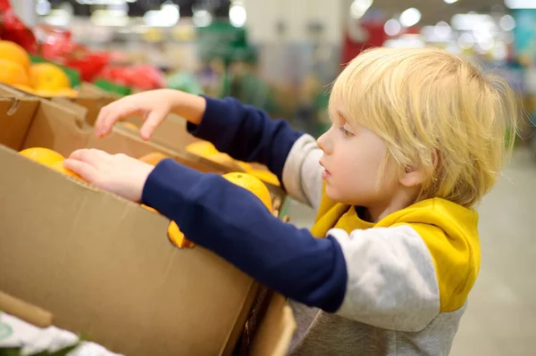 Leuk Jongetje Een Levensmiddelenwinkel Supermarkt Die Verse Biologische Sinaasappels Kiest — Stockfoto