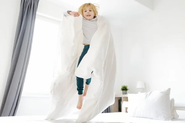 Χαρούμενο Αγοράκι Τις Πιτζάμες Πηδάει Στο Κρεβάτι Των Γονιών Του — Φωτογραφία Αρχείου