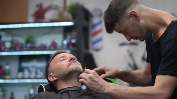 Barber Master Shaving Handsome Mature Bearded Man Using Electric Shaver — Video Stock