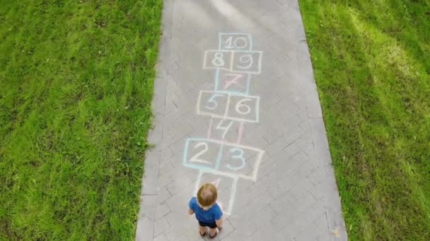 Luchtfoto Van Kleine Jongen Springen Door Hopscotch Getrokken Asfalt Kind — Stockvideo