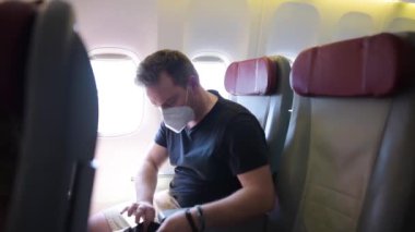 Uçakla seyahat eden orta yaşlı bir adam. Uçakta oturan ve uçuş sırasında emniyet kemerini bağlayan yolcu. Sinek ulaşımının güvenliği ve korunması