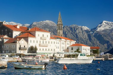 Perast, Karadağ - 16 Mart 2022: Karadağ 'ın antik Perast kentinin manzarası. Kırmızı çatıları ve arka planında görkemli dağları olan eski bir ortaçağ kasabası..