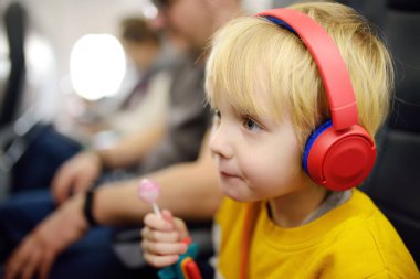 Uçakla seyahat eden sevimli bir çocuk. Çocuk uçuş sırasında müzik dinlemek ya da sesli kayıt yapmak için oyuncu kullanıyor. Uçakta çocuklu bir aile eğlencesi.