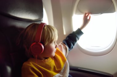Uçakla seyahat eden sevimli bir çocuk. Çocuk uçuş sırasında müzik dinlemek ya da sesli kayıt yapmak için oyuncu kullanıyor. Uçakta çocuklu bir aile eğlencesi.