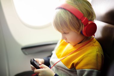 Uçakla seyahat eden sevimli bir çocuk. Çocuk uçuş sırasında müzik dinlemek ya da sesli kayıt yapmak için oyuncu kullanıyor. Uçakta çocuklu bir aile eğlencesi.