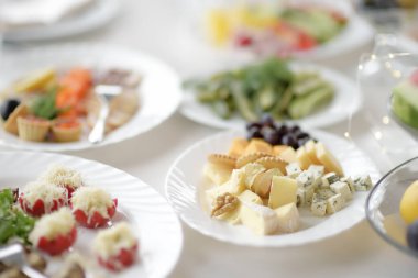 Bir parti, düğün resepsiyonu ya da şenlik için güzel bir masa. Meyveler, atıştırmalıklar ve akşam yemeği için aperatifler. Şık çiçek buketi.