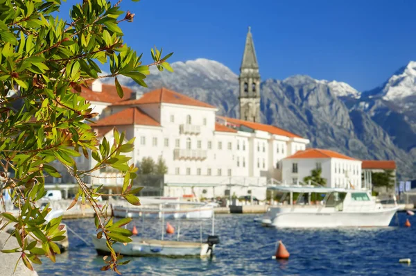 Karadağ 'ın antik Perast kentinin resimli manzarası. Adriyatik denizinin arka planında kırmızı çatıları ve görkemli dağları olan eski bir ortaçağ kasabası. Tekneli ünlü Kotor Körfezi.